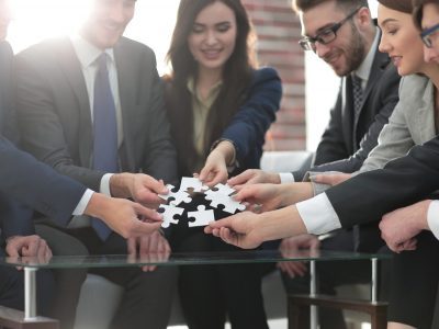 Business team solving puzzle together. Hybrent's Implementation Team is with you every step of the way